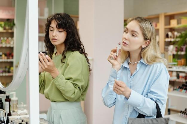 Two women trying out beauty products in a cosmetics store