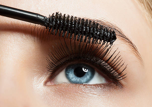 Close-up of a woman applying mascara to her eyelashes